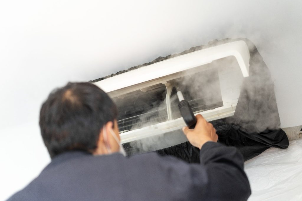 A Worker Fogging an HVAC Unit | Air Duct Sanitizing vs Deodorizing | Envirovac